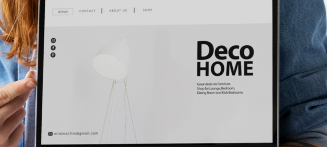 Iemand met een tablet waarop een minimalistische website over woninginrichting te zien is, „DECO HOME“, gebouwd met WordPress.